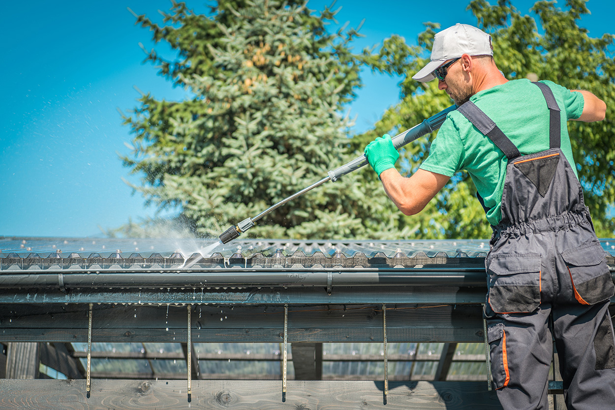 An Expert Cleaning a Gutter